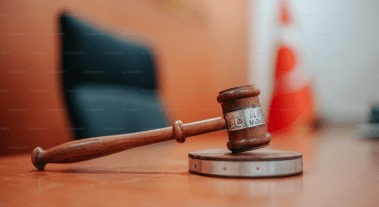 a wooden gavel on a round metal disc